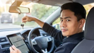 Conductor sosteniendo las llaves de su auto mientras revisa su póliza de seguro en una tablet.